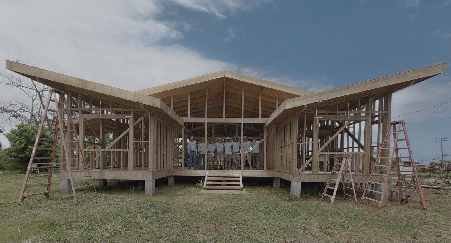 The framed structure of the Kapa‘a home with its lifted roof, ladders at each end